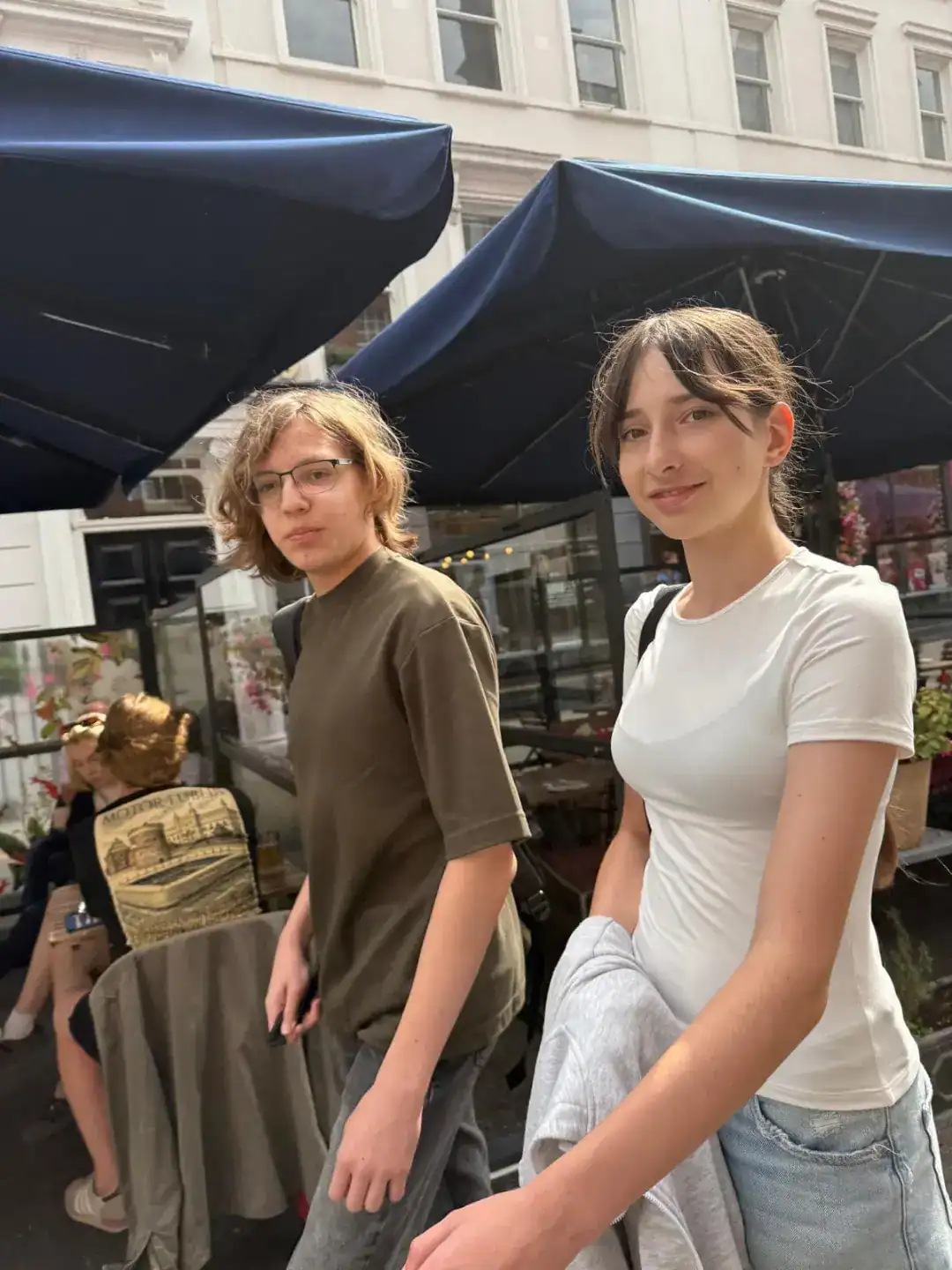 Youthful students outdoors at a cafe, emphasizing international school community and diverse student life.