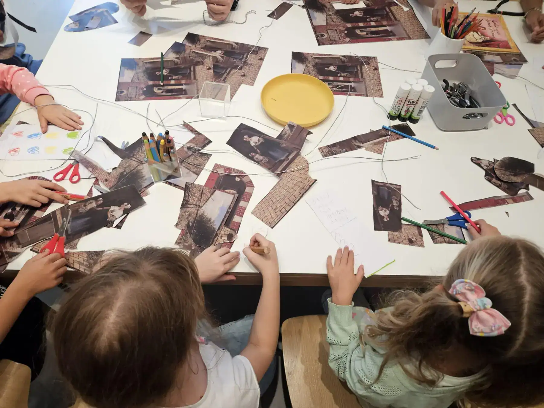 Creative group art project with children making collages and crafts, fostering creativity and teamwork.