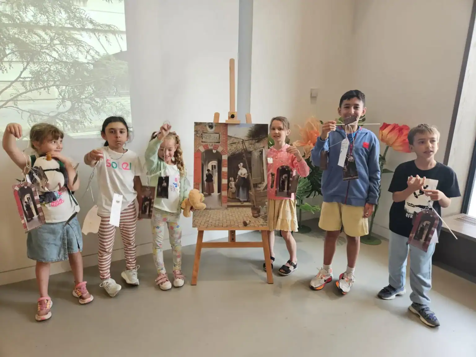 Colorful children holding artwork and crafts at World Schools art event.
