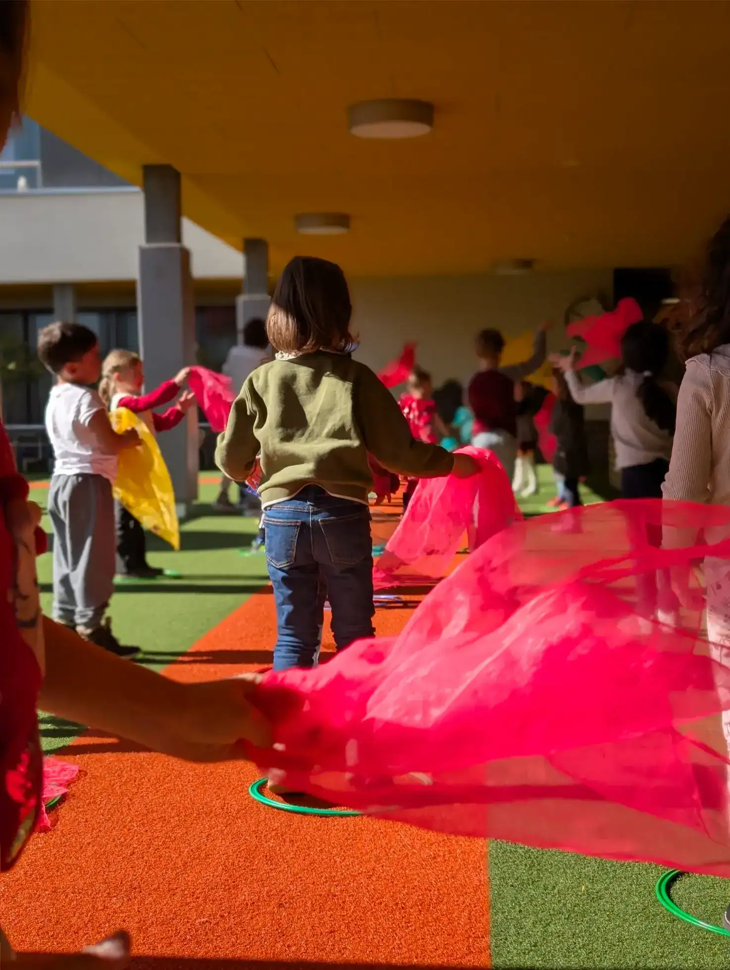 Colorful children playing with fabric in an outdoor school area at World Schools.