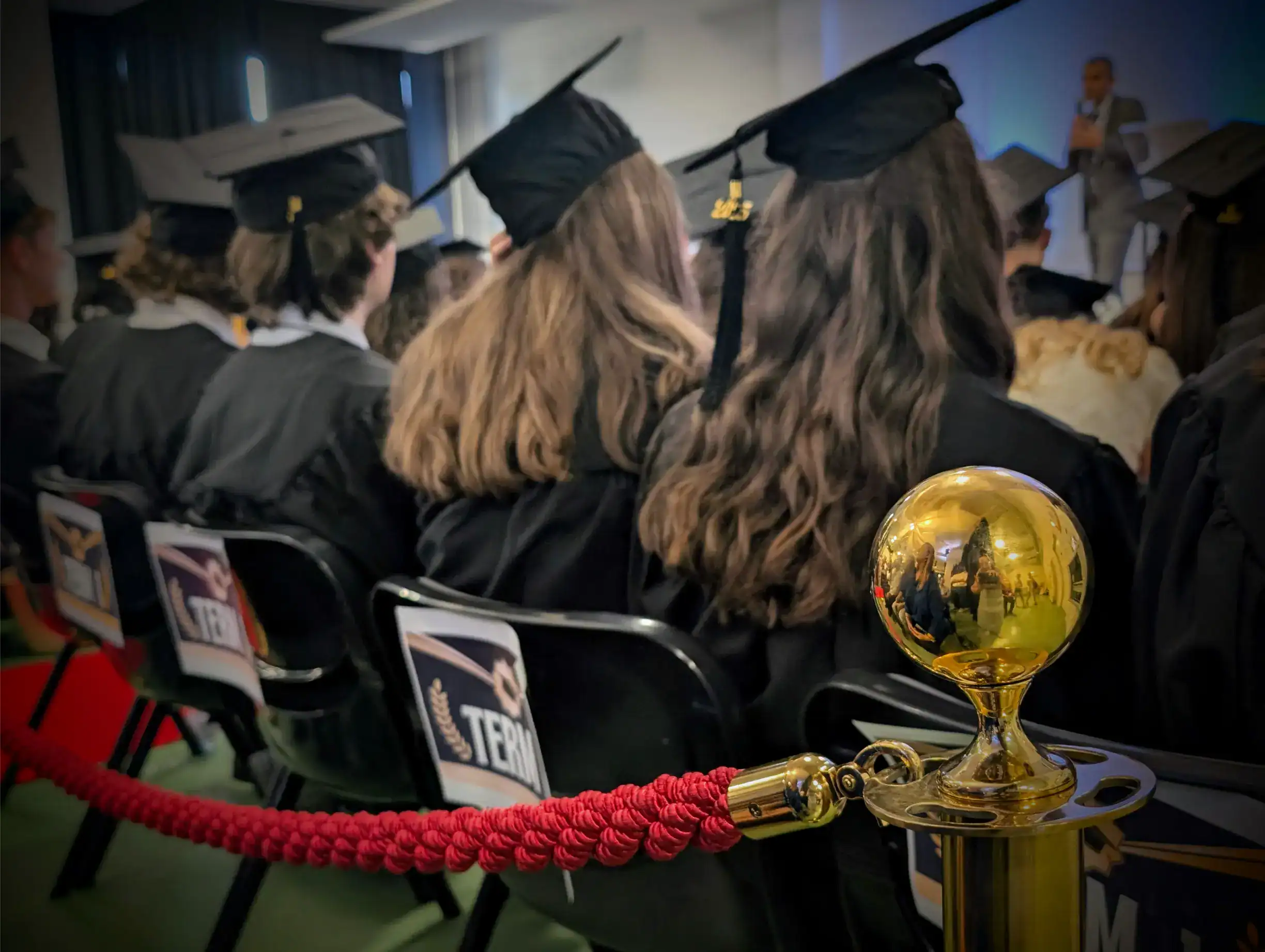 Students in graduation caps and gowns at a school ceremony, celebrating academic achievement and success.