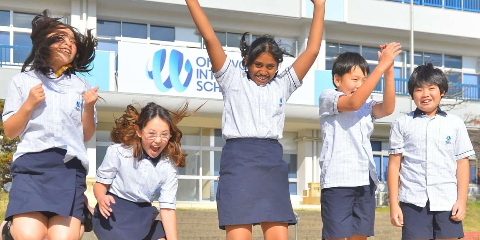 Bright diverse students celebrating joyfully outside World Schools campus, promoting global education excellence.