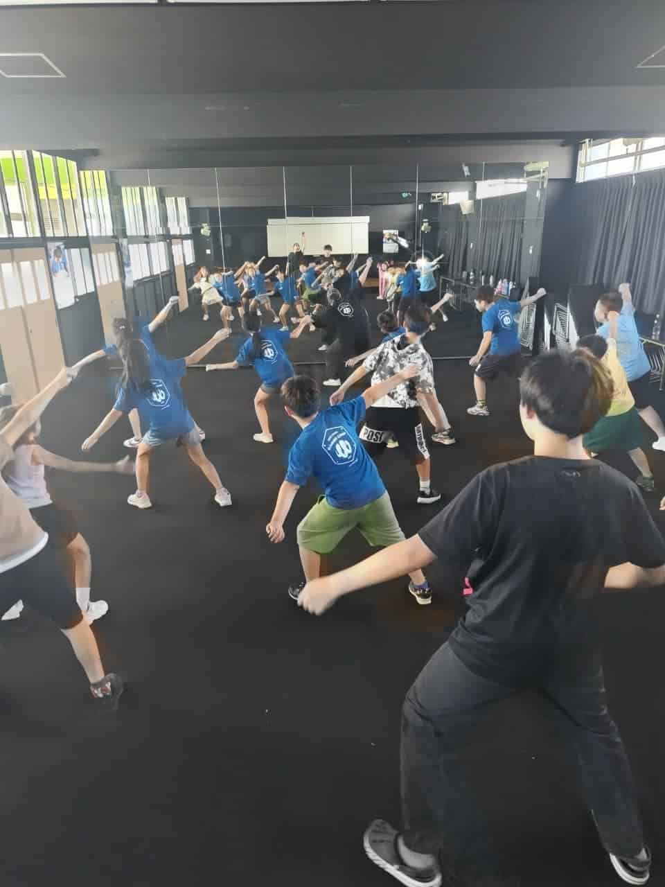 Engaging students participating in a fitness class at a modern, well-equipped international school gym.