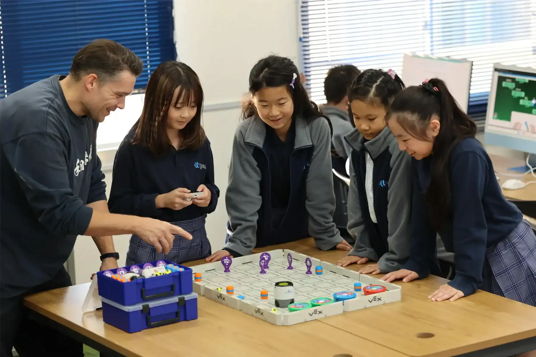 Interactive robotics class in international school, students engaging in STEM education.