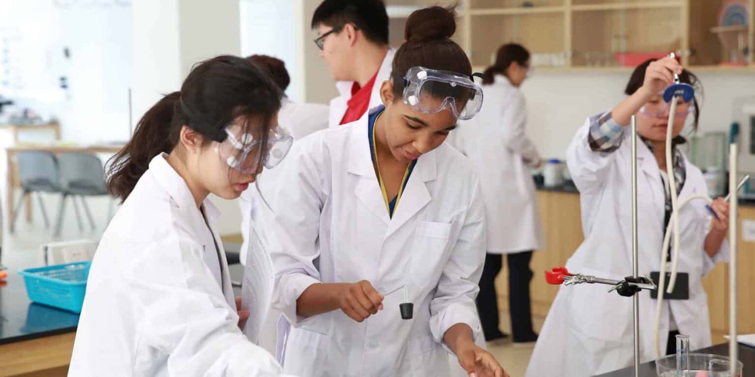 Leerlingen voeren wetenschappelijke experimenten uit in een klaslokaal in een World Schools-programma, dat de nadruk legt op internationaal onderwijs en bèta/technische uitmuntendheid.