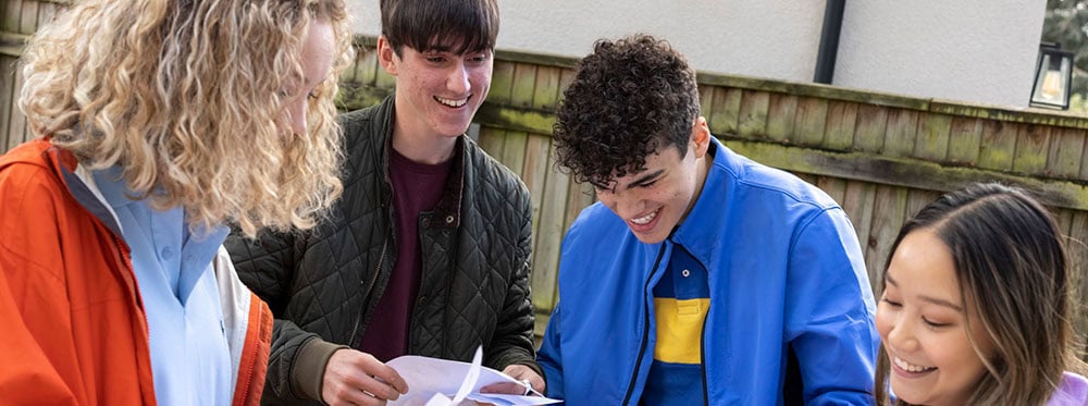 Diverse group of students studying outdoors at a World Schools educational event.