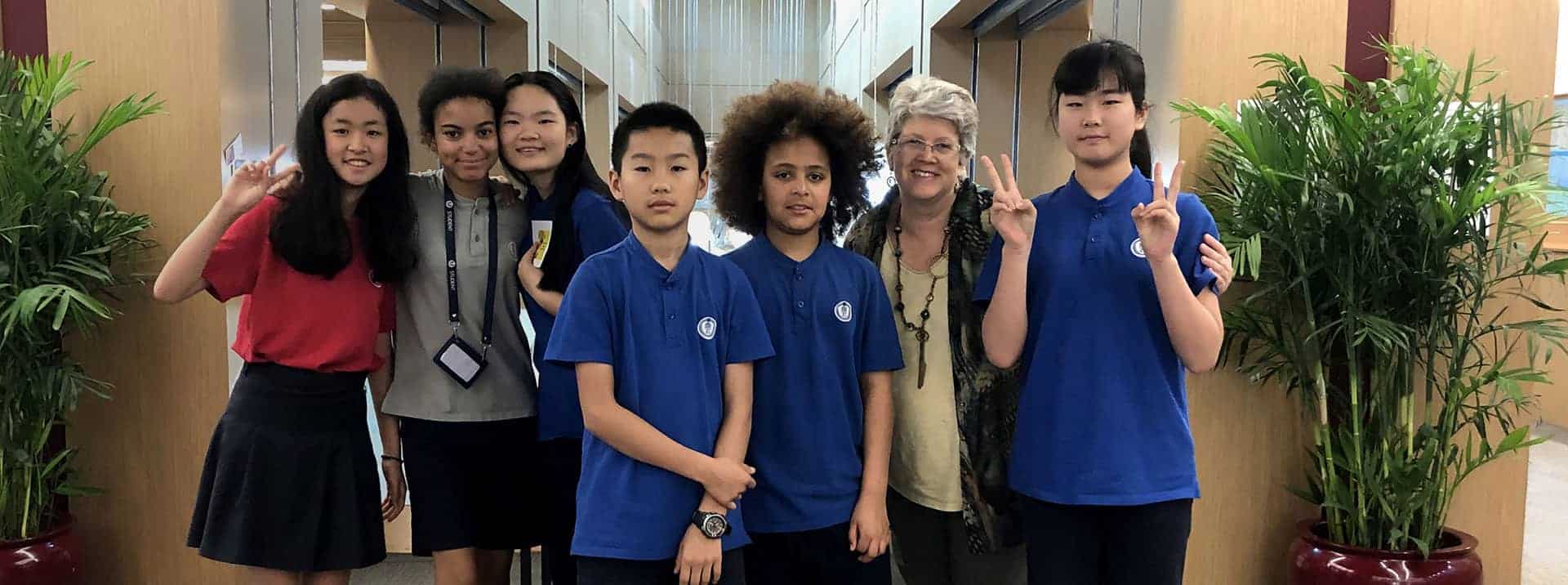 Diverse students at World Schools with teacher in modern educational environment.