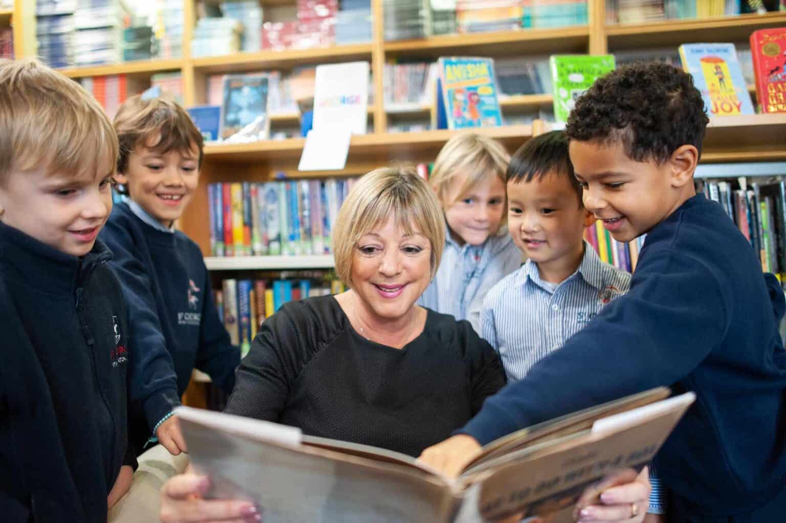 Bambini in biblioteca con un insegnante, impegnati in un'attività di lettura per promuovere l'alfabetizzazione e l'amore per l'apprendimento.