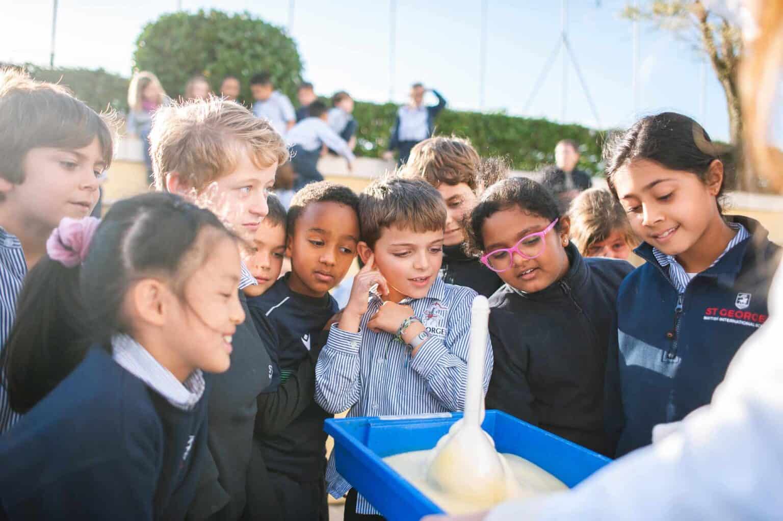 Studenti impegnati in un'attività scientifica all'aperto in un campus di una scuola mondiale per l'educazione globale.