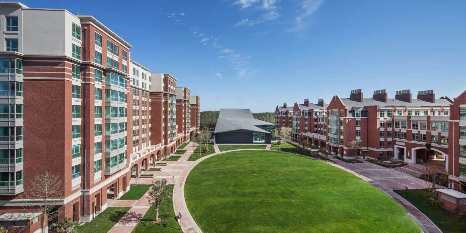 Moderne universiteitsresidenties met weelderige groene binnenplaats voor internationale studenten en wereldwijd onderwijs.