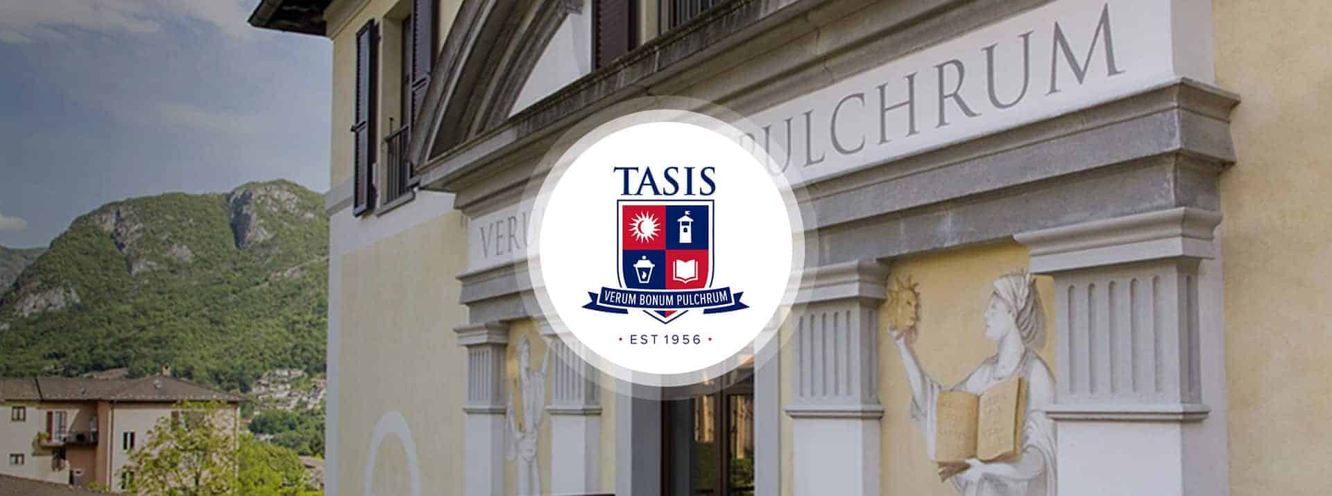 Elegant school entrance at Tasis with historic architecture and scenic mountains in background.