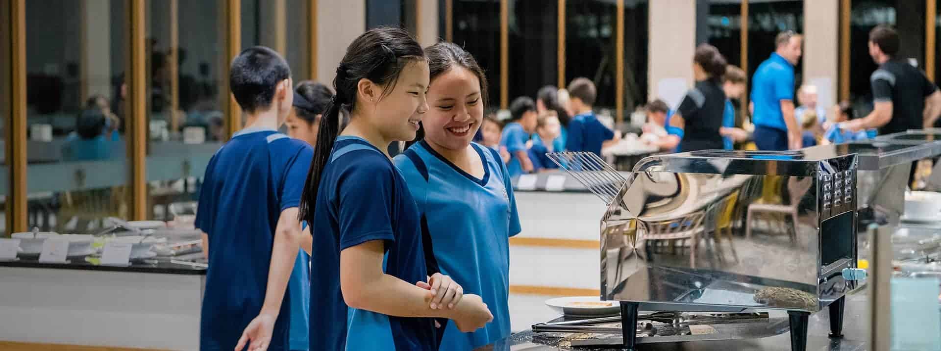 1. Smiling students in blue school uniform enjoying school cafeteria experience at World Schools.