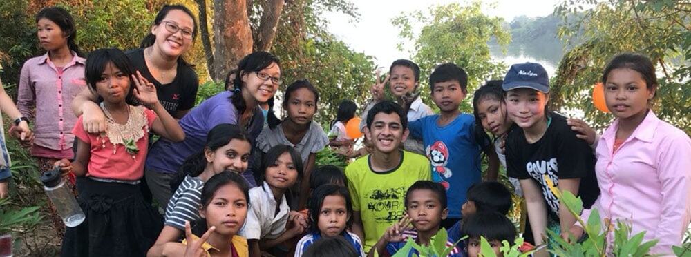Happy children and teachers outdoors at a World Schools educational program focused on global learning and cultural exchange.