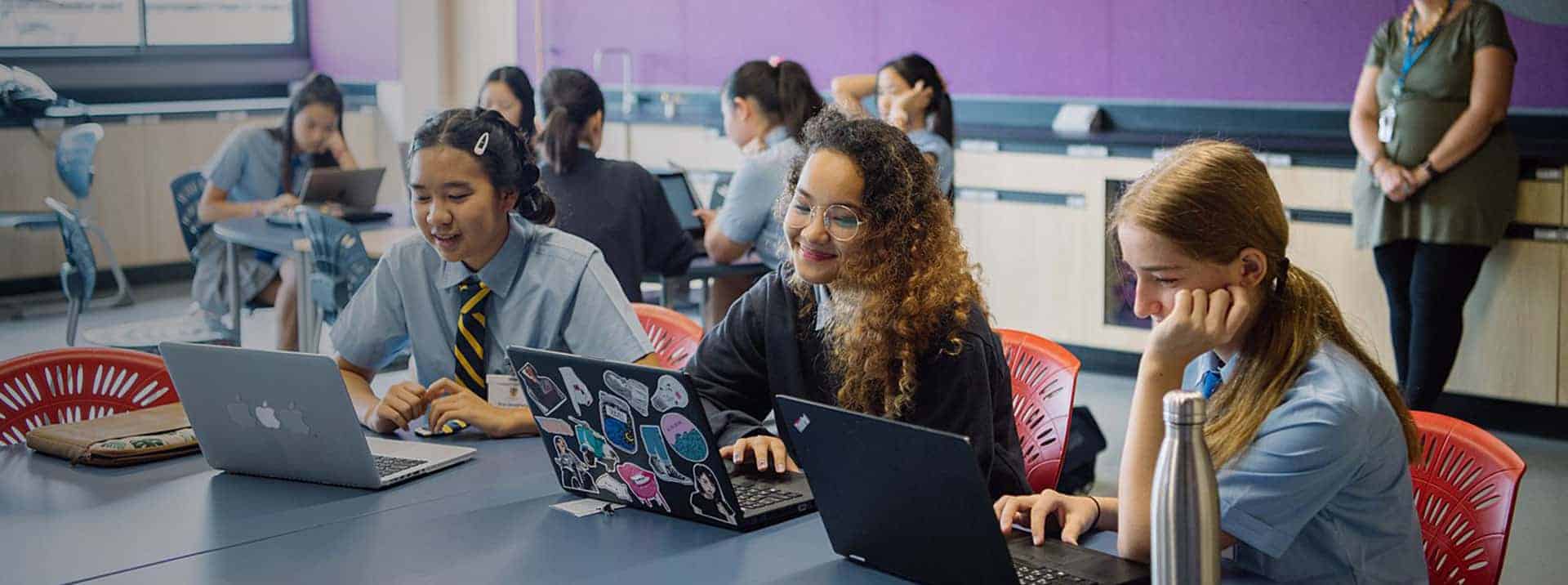 ULTIMATE SCHOOL LEARNING ENVIRONMENT WITH STUDENTS USING LAPTOPS IN CLASS.