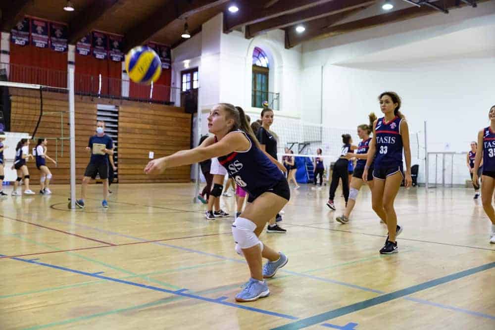 Amateur girls volleyball game at World Schools sports facility for global education excellence.
