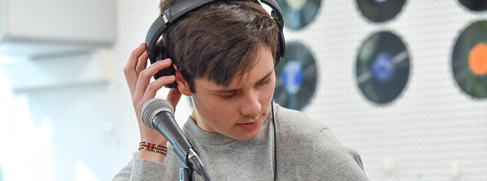 Engaging student with headphones at world-schools.com, promoting international education excellence.