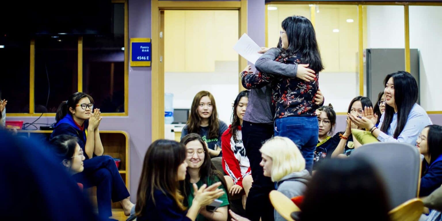 Diverse groep studenten en docenten vieren prestaties op een internationaal schoolevenement.