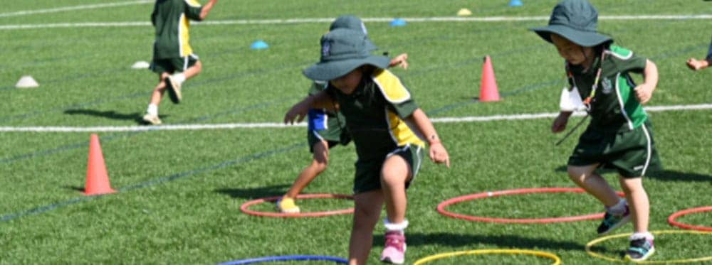 Bright young children participating in outdoor sports activity at a world school sports event.