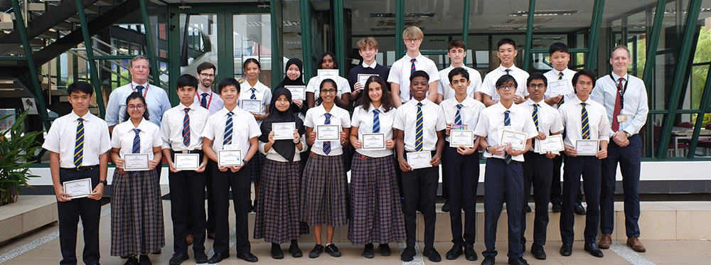 1. Smiling international students with certificates at World Schools graduation event for global education.