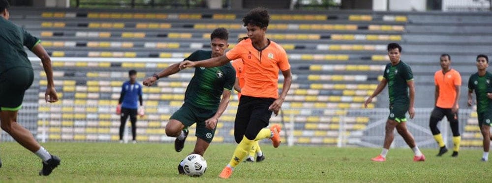 Youth soccer players competing on a field at World Schools sports event.