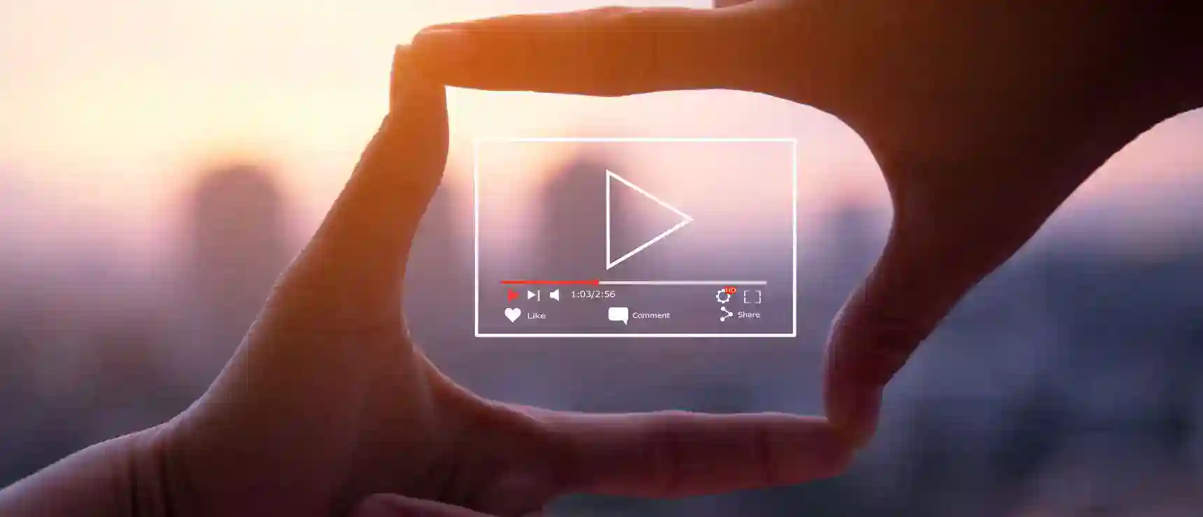 Hand holding a digital video icon at sunset, symbolizing online learning and global education.