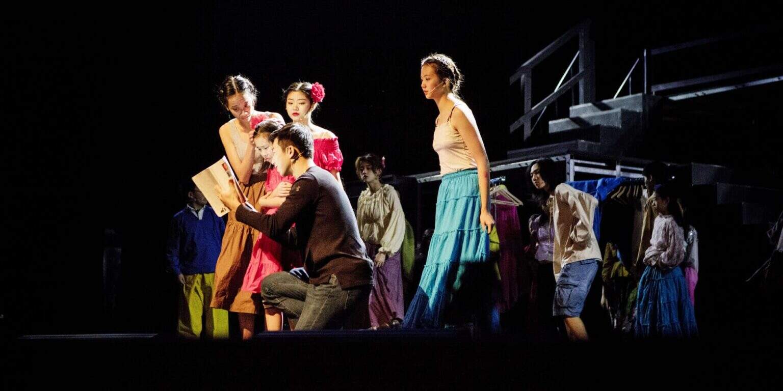 Kinderen treden op in een schooltoneelstuk, waarmee ze de creatieve kunsten en het dramaonderwijs op Wereldscholen onder de aandacht brengen.