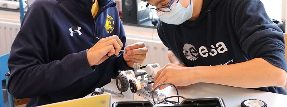 Hands-on STEM activity with students working on robotic projects at a school, promoting innovation and technological skills.