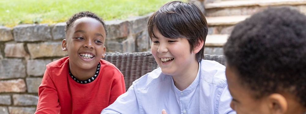 Diverse happy students engaging outdoors at a world school, promoting inclusive international education.