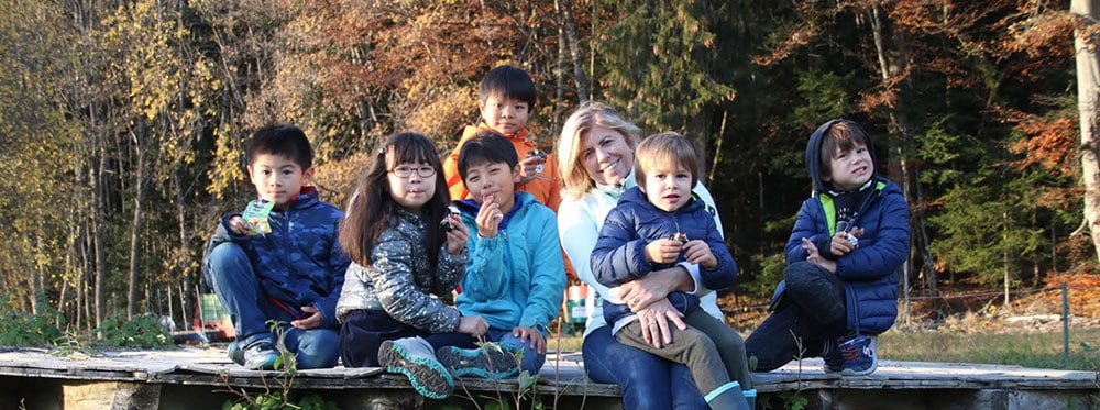 Children enjoying outdoor learning at a world school in a natural setting.