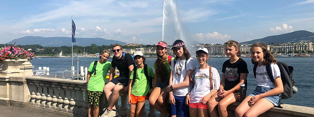 Students enjoying a cultural trip by the waterfront with scenic city views, perfect for international school travel experiences.
