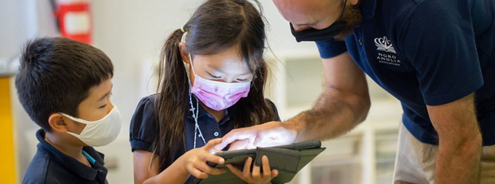 Engaged children using digital learning tools in a classroom environment for world school education.