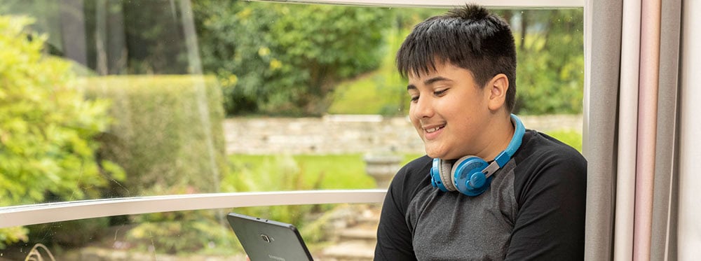 Enjoying outdoor learning with a tablet in a lush garden setting at a world school.