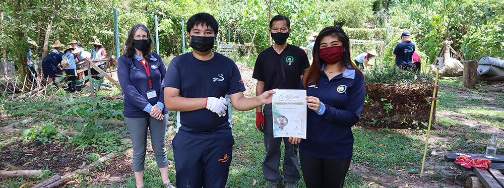 Students receiving environmental certification at a sustainable school planting event.