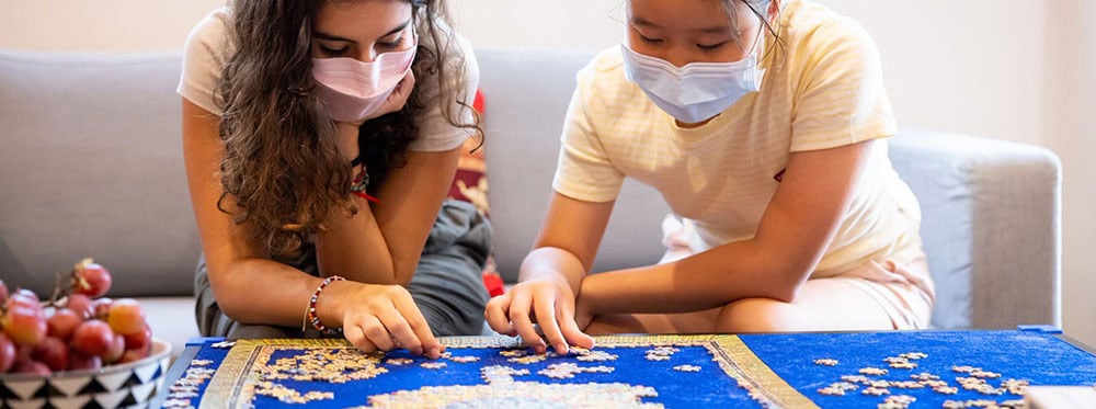 Girls playing puzzles at a World Schools educational environment, promoting active learning and global citizenship.