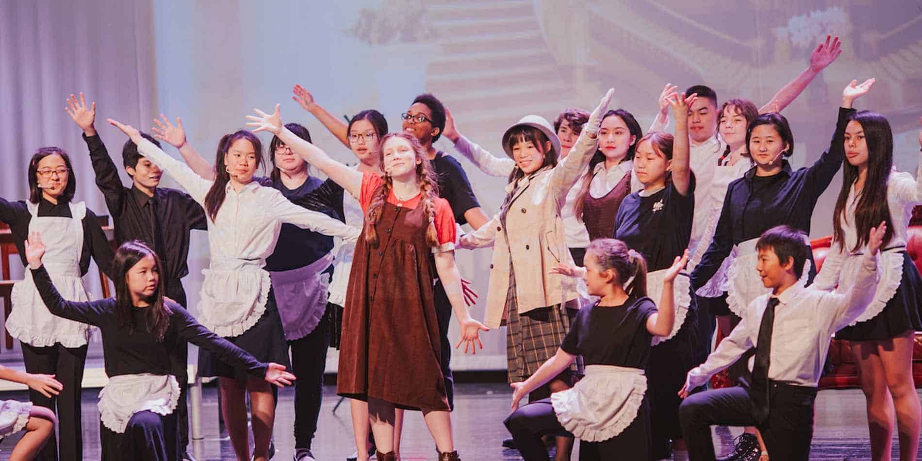 Diverse students performing on stage during school event at World Schools, emphasizing international education excellence.