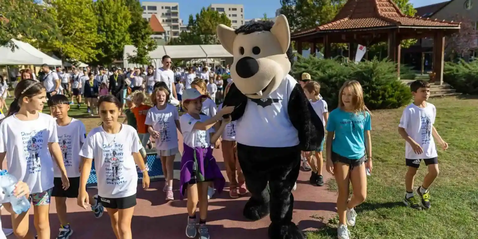 Happy children enjoying outdoor school event with mascot at World Schools.