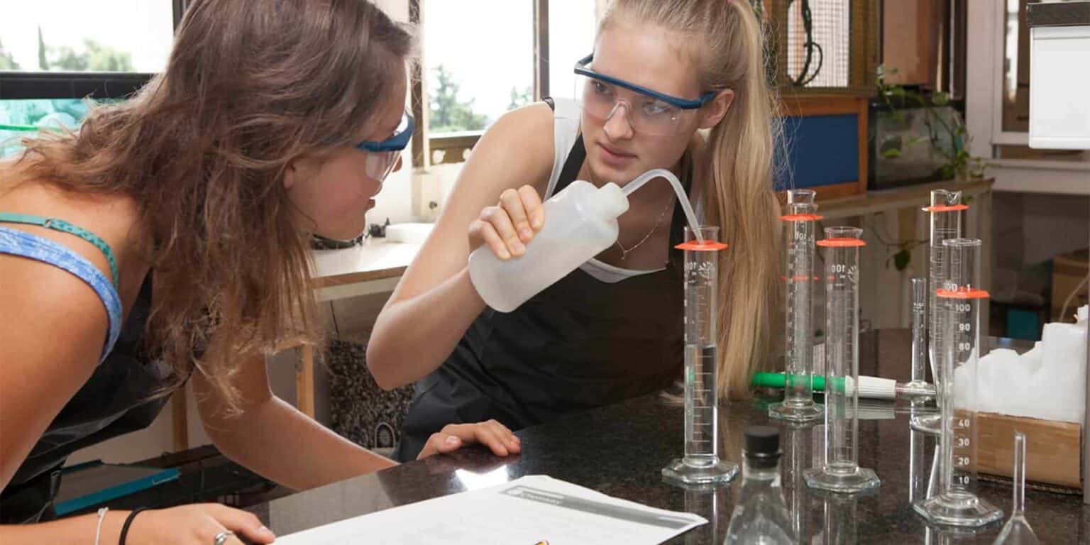Lab students conducting chemistry experiment in school science lab, focus on safety and learning, educational environment for young learners.