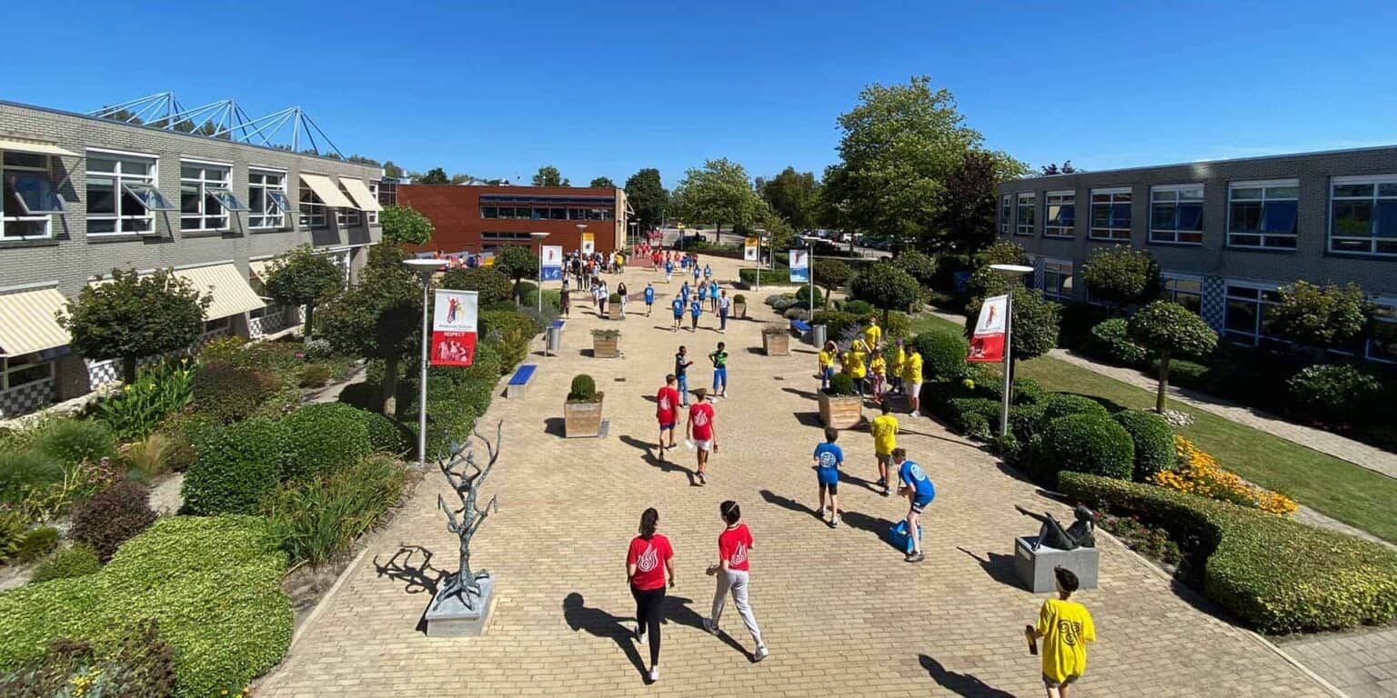 Students walking and socializing on a sunny school campus at World Schools, vibrant and modern learning environment.