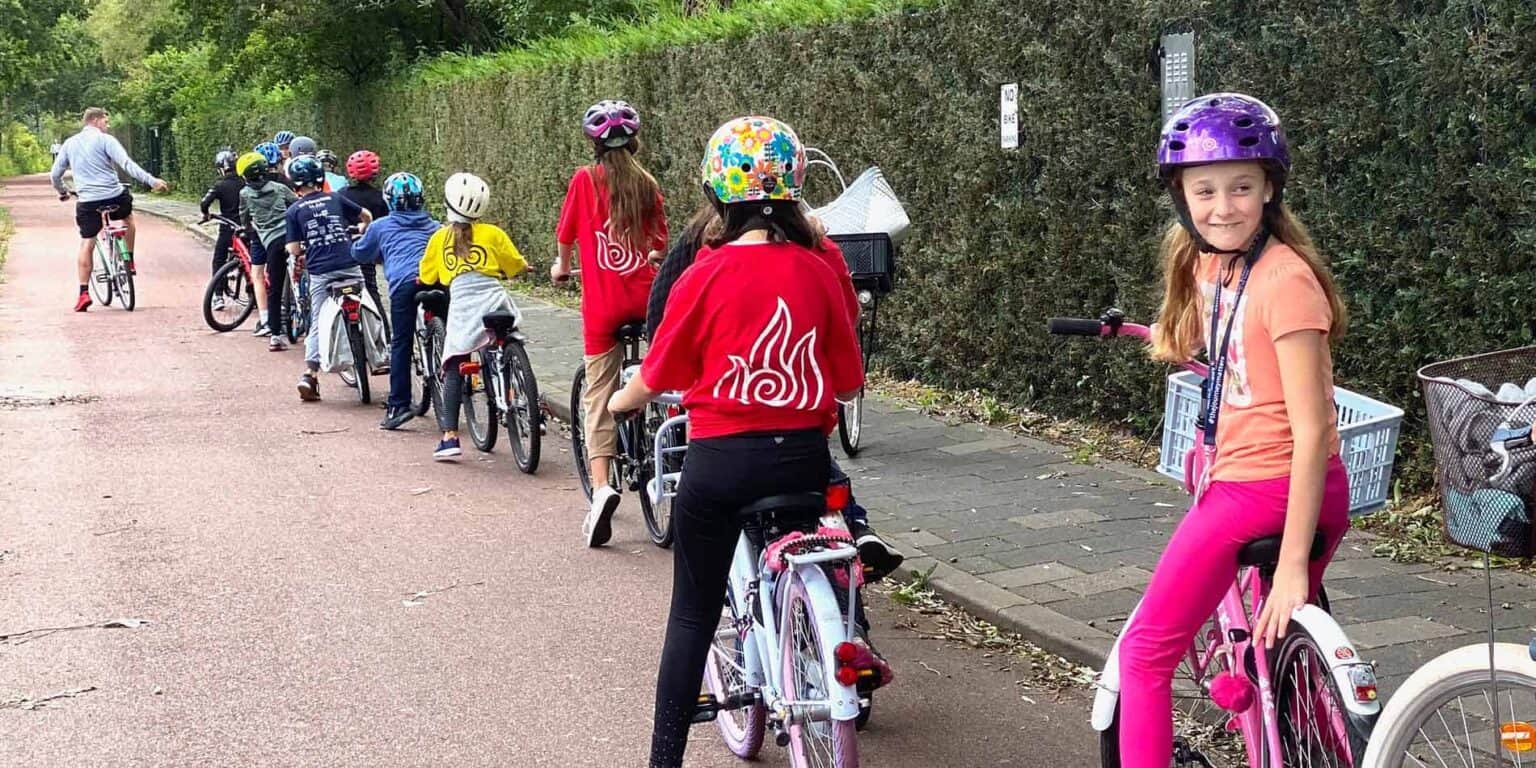 Children riding bicycles in a school activity on a scenic path for world schools.