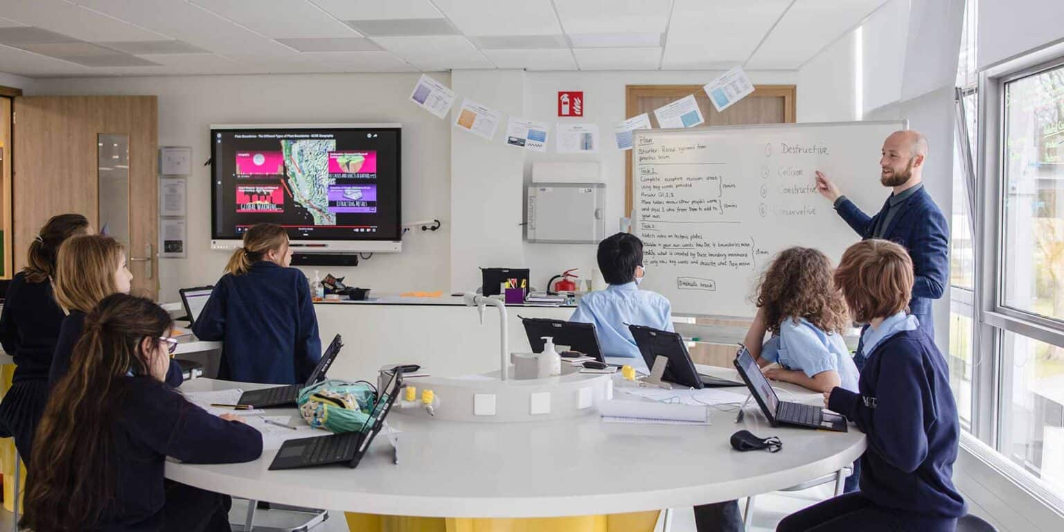 学生和教师使用数字智能板的互动教室,现代化的学校环境。.