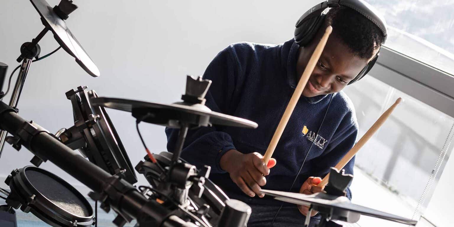 在一所国际学校从事音乐教育的儿童在玩电子鼓。.