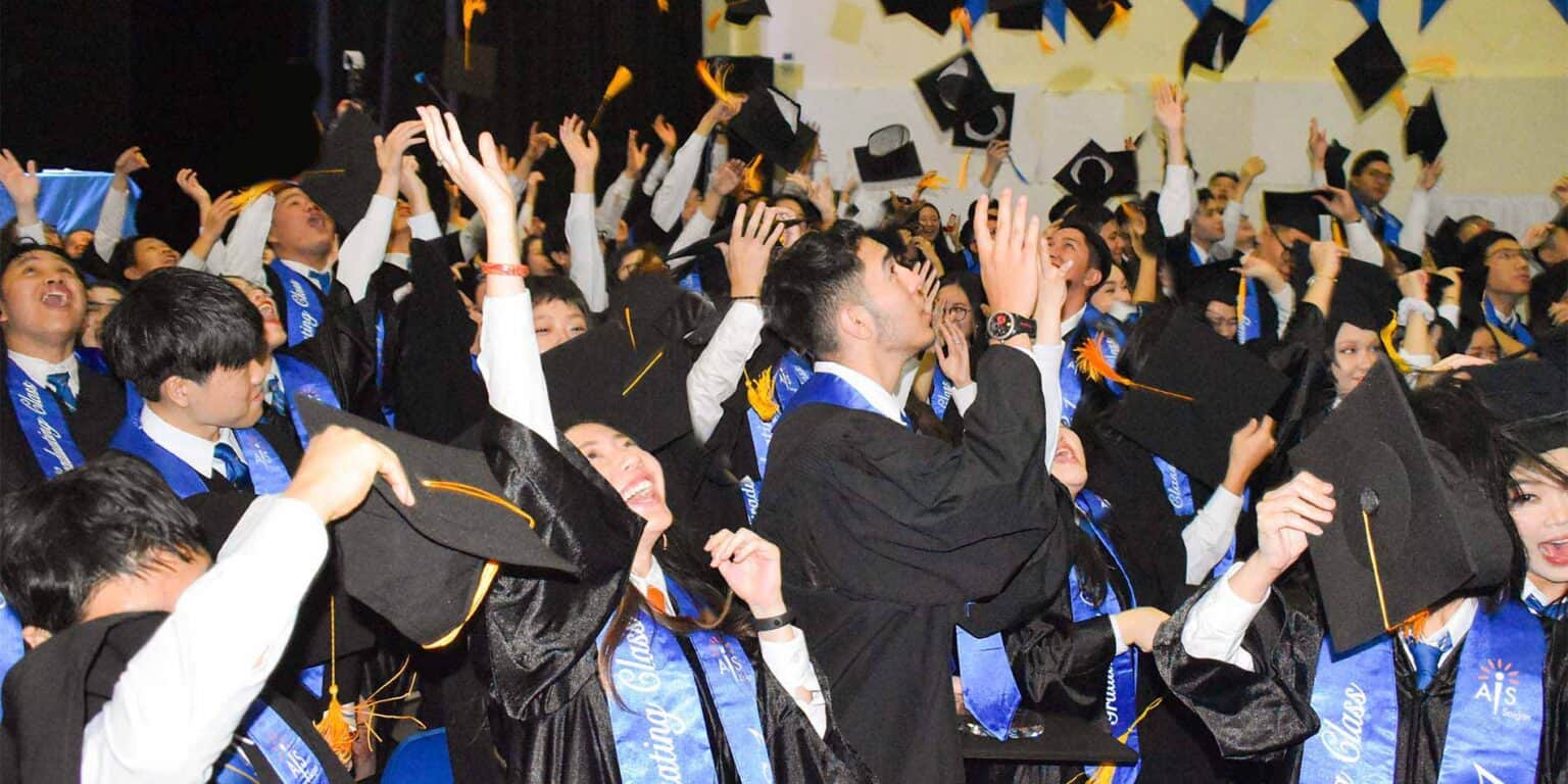 Graduates celebrating at a world schools graduation ceremony, joyful students in academic caps and gowns.