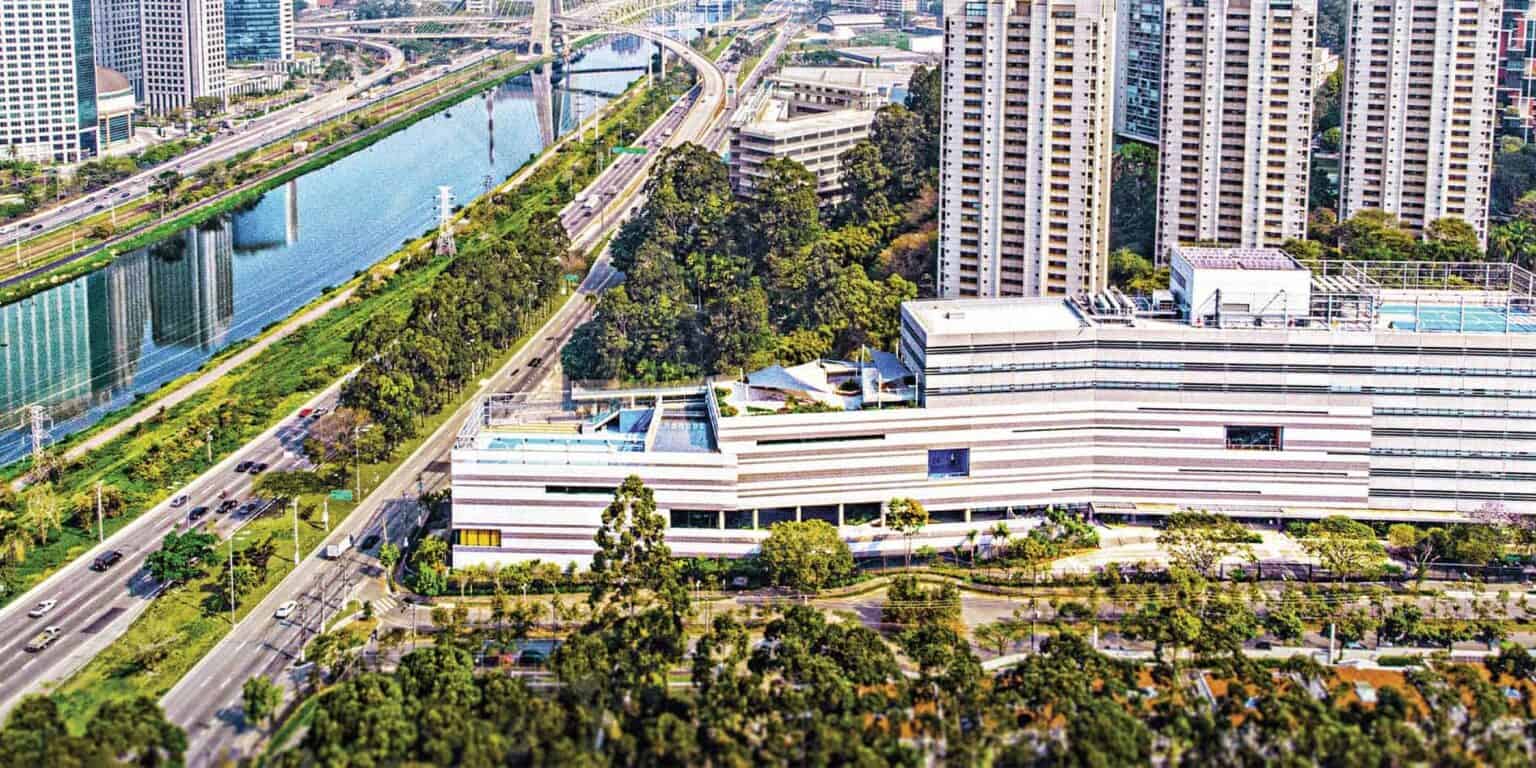 Modern urban school campus with high-rise buildings and lush greenery, located in a vibrant city setting.