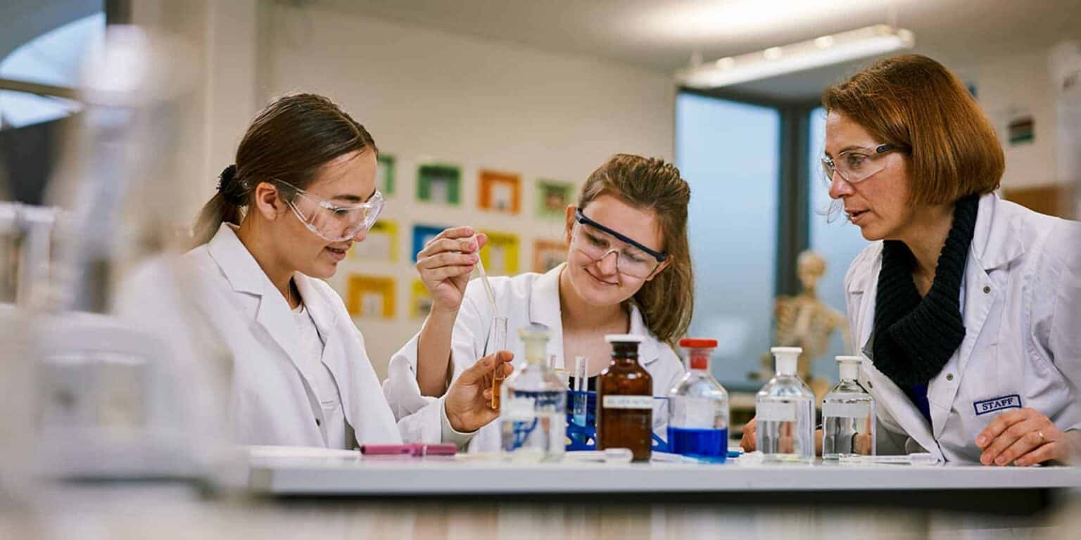 Laboratory students conducting science experiments in a modern classroom at a world-class international school.