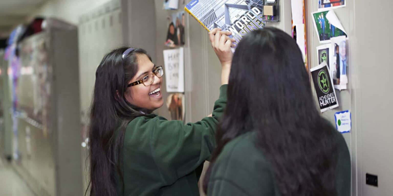 Bright high school students engaging in a collaborative activity at a school locker, promoting an innovative learning environment.