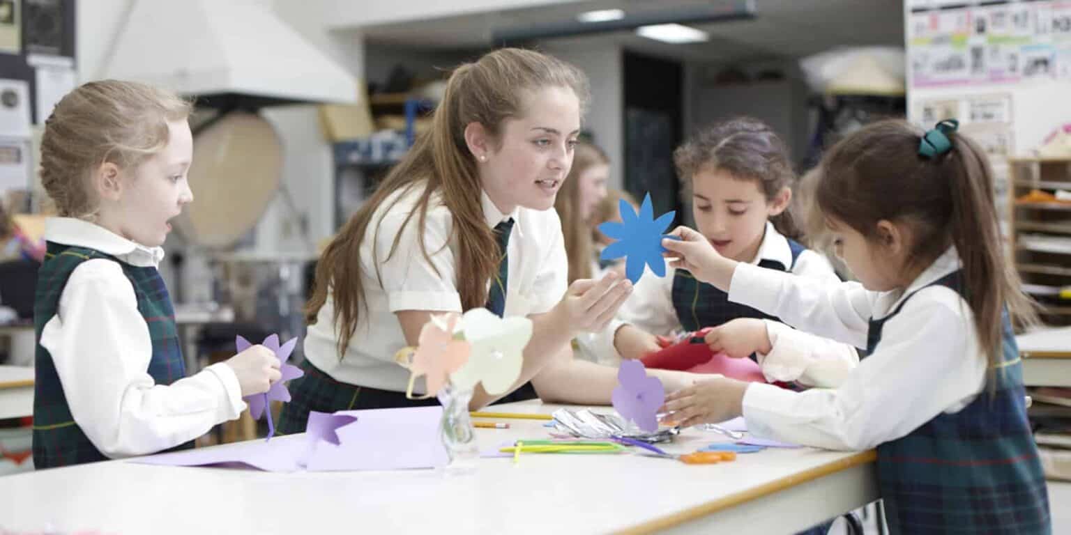 Colorful classroom with young students engaging in arts and crafts activity.