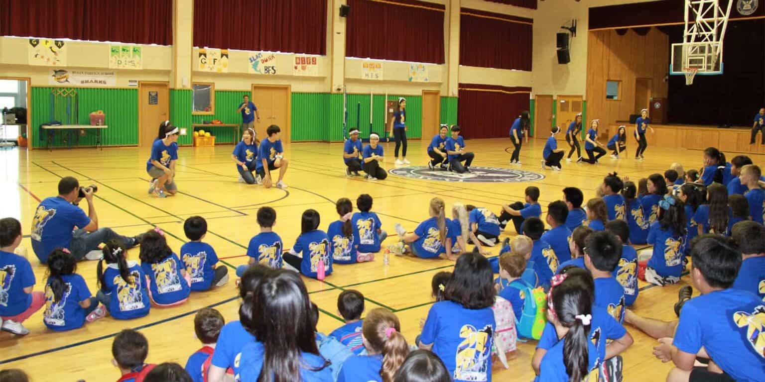 Students participating in a school event in a gymnasium for World Schools.