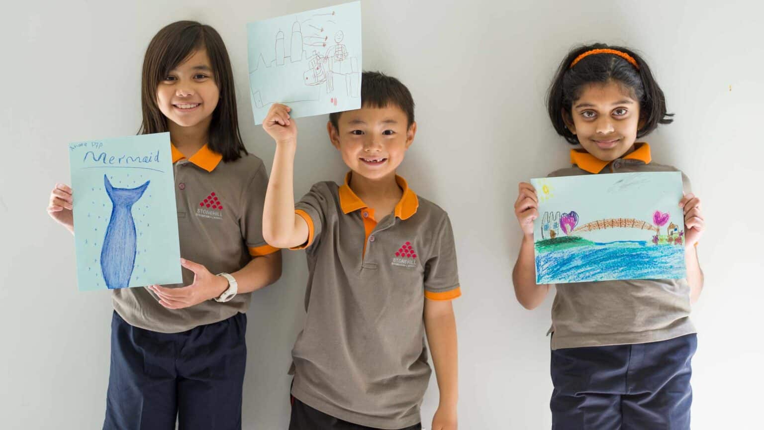 Bright young students showcasing their artwork at World Schools, fostering creativity and diverse learning environments.