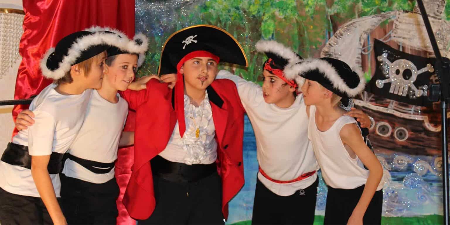 Pirate-themed school performance featuring children in costumes, promoting creativity and teamwork.