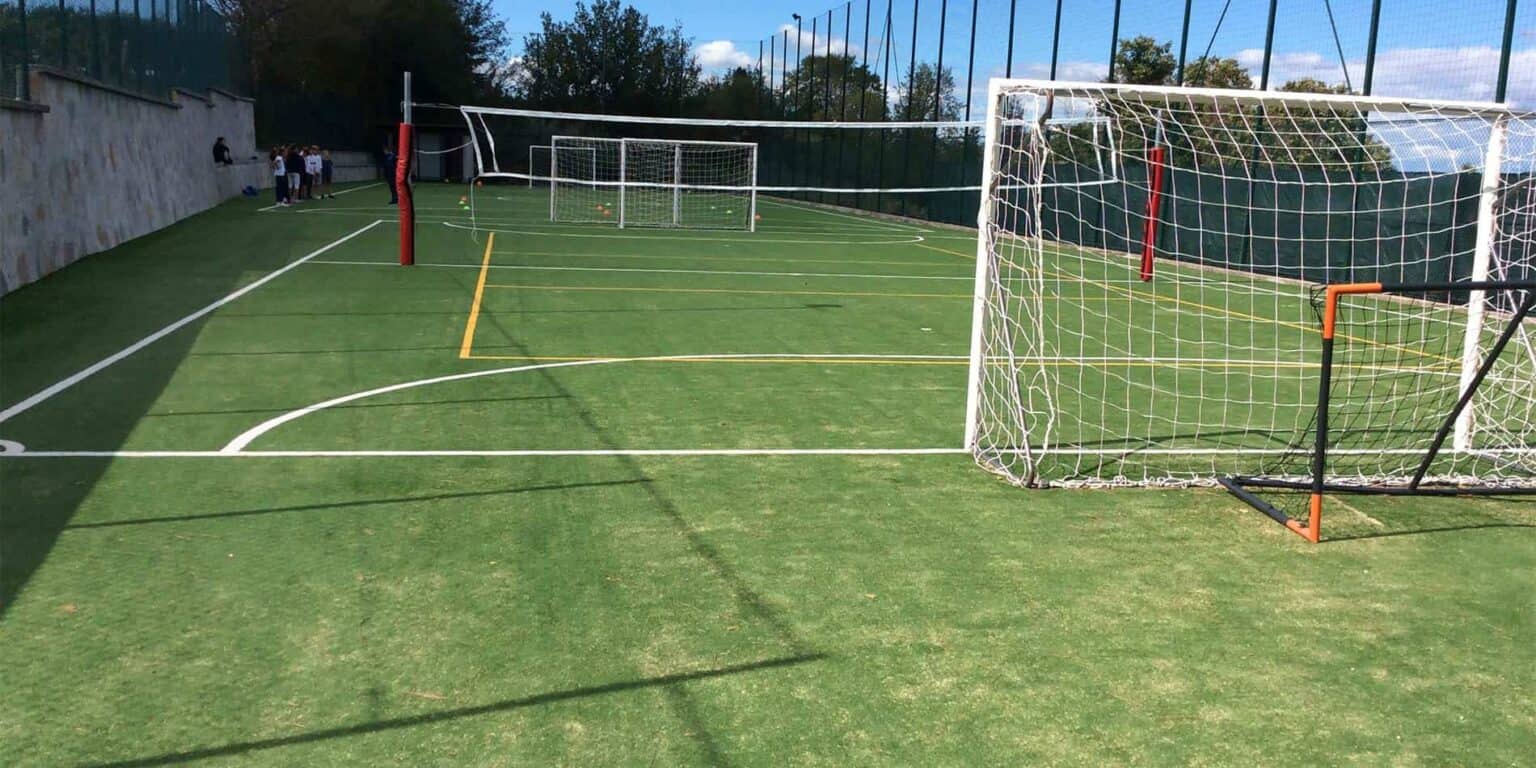 Bright outdoor tennis court at World Schools, featuring multiple goals and a vibrant sports environment.